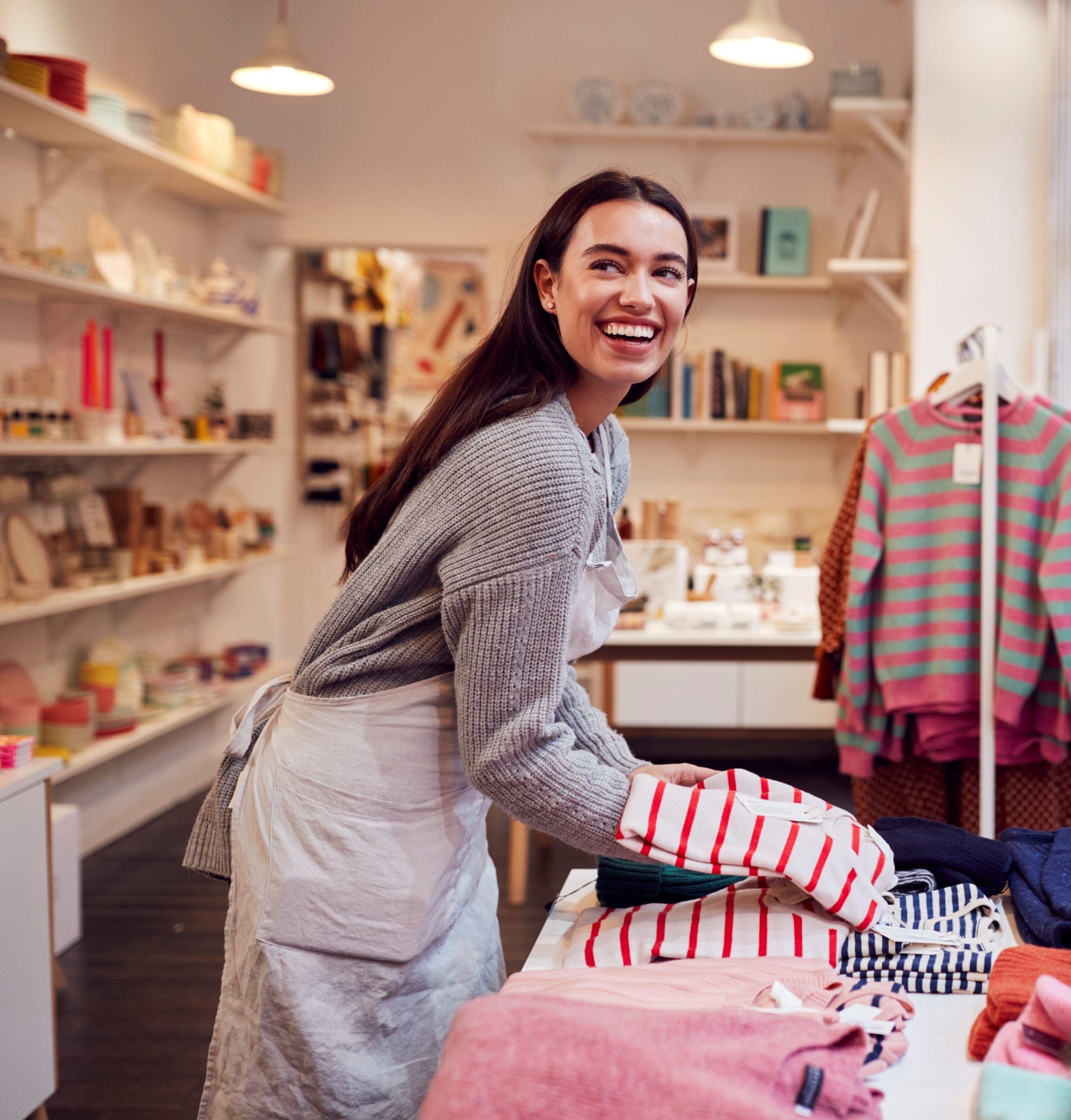 Female Small Business Owner Arranges Stock In Window Display