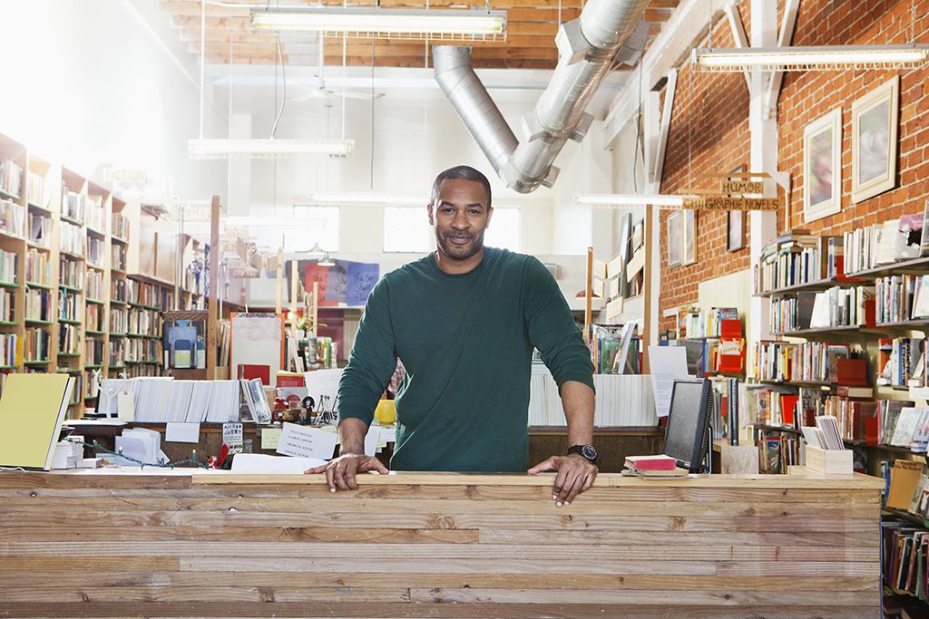 African American Male bookshop owner smiling proudly