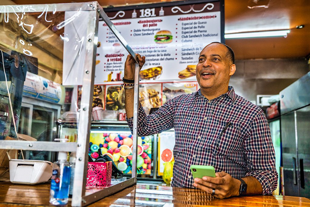 Eleazar Bueno, de Empanadas Monumental, sonríe a los clientes que entran en su pequeño negocio
