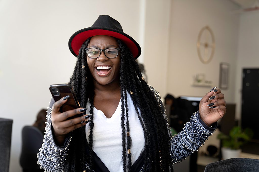 Marie Theodore of small business Playbook MG laughing and looking at her phone