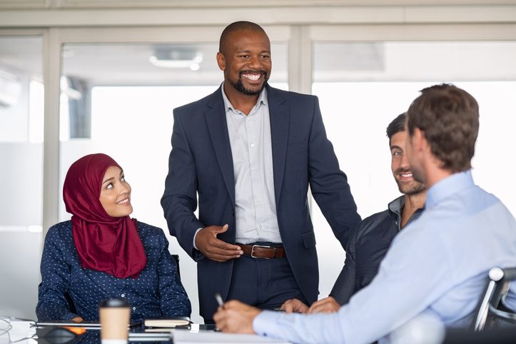 African American male leading a team of multiethnic employees in a meeting