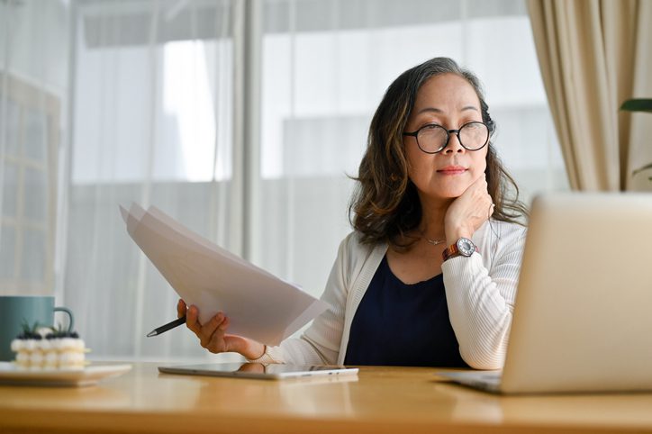 Concentrated asian female business owner preparing financial documents