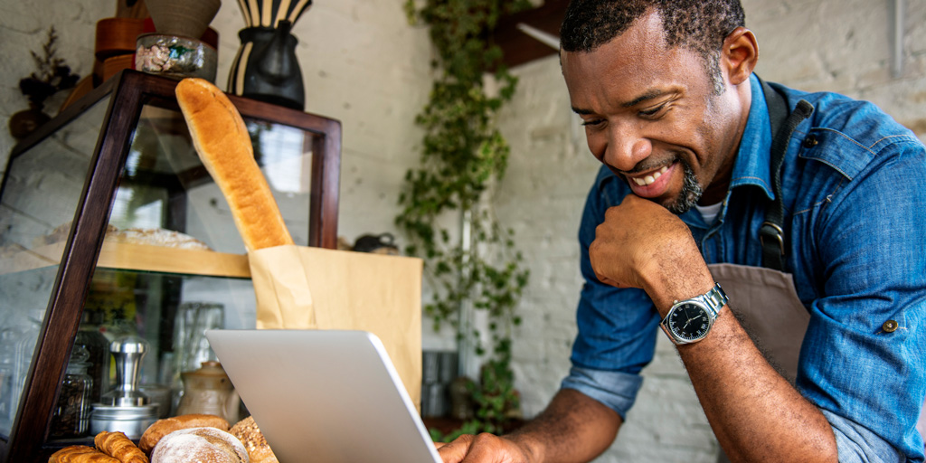 Man using devices for online business order at bakehouse