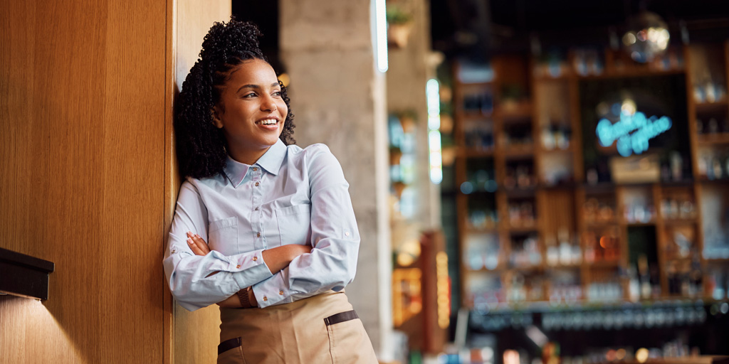 Confident African American waitress in a cafe looking away.