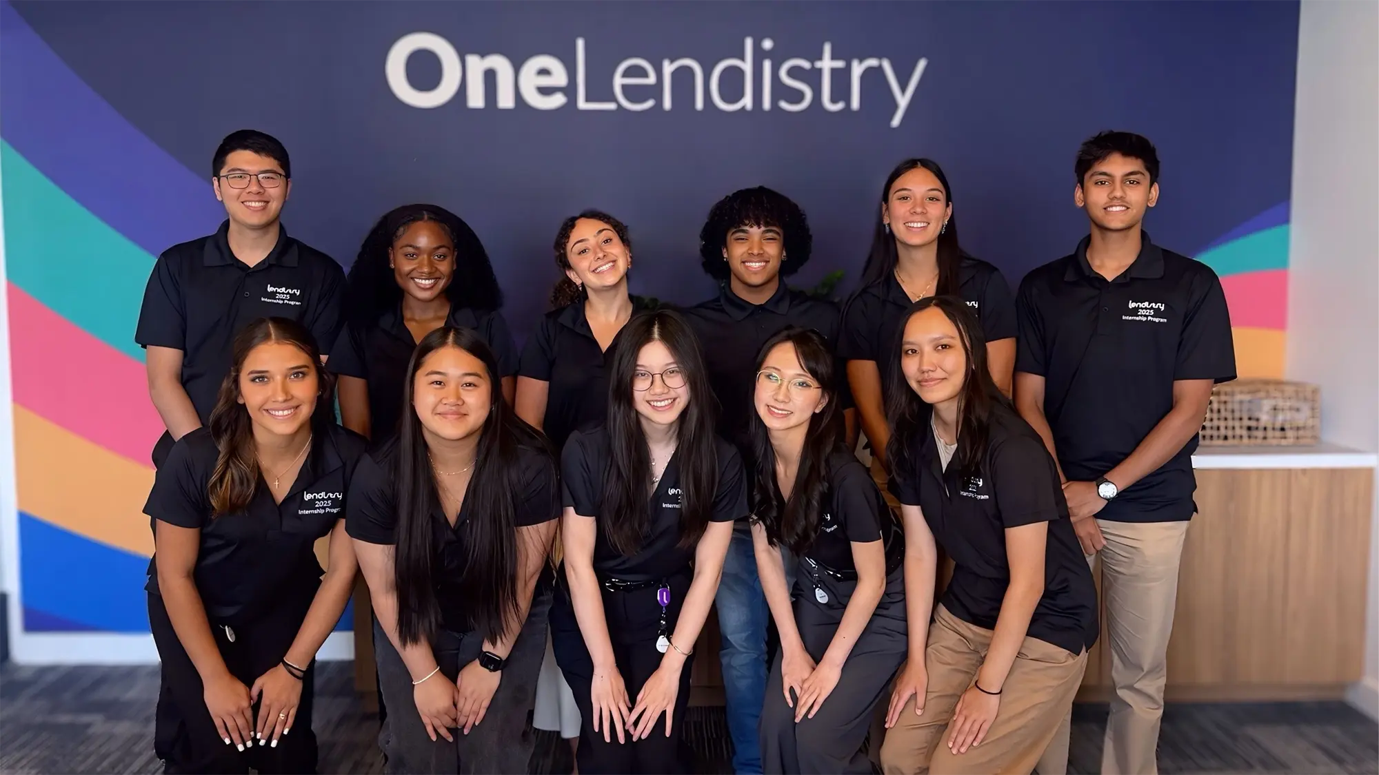 Group photo of Lendistry's 2025 internships standing in front of One Lendistry wall