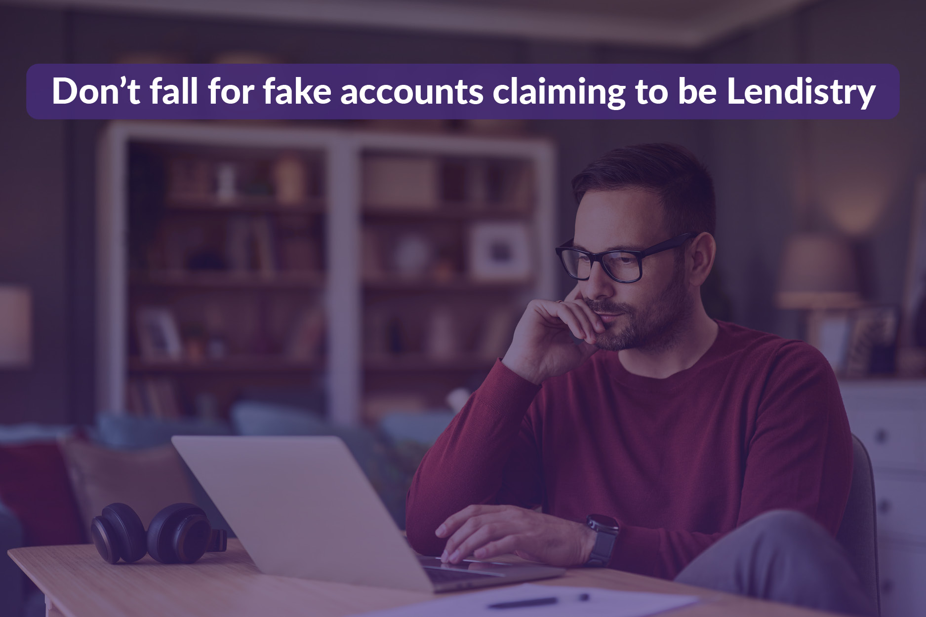 Image of an individual looking at a laptop with a serious face. Text "Dont fall for fake accounts claiming to be Lendistry"