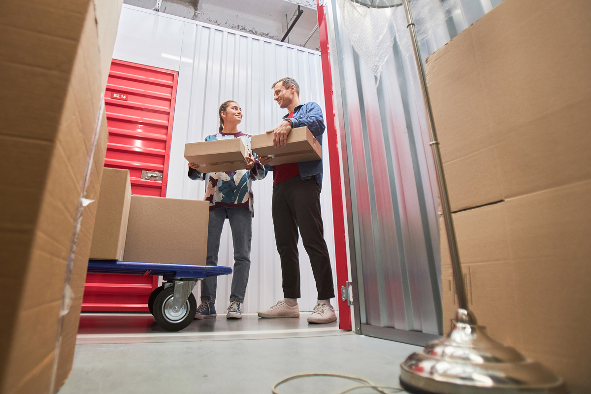 2 business owners smiling while loading a storage unit