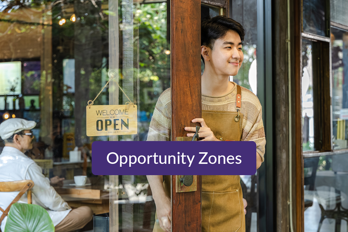 Smiling business owner holding open the door of his small business